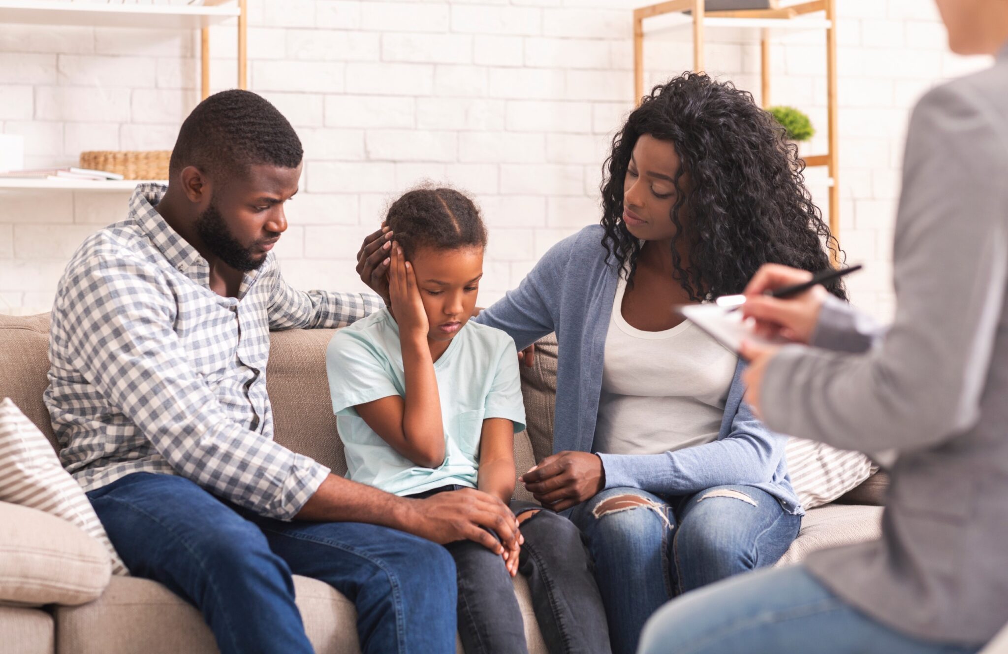 des parents et une petite fille qui se tient l'oreille