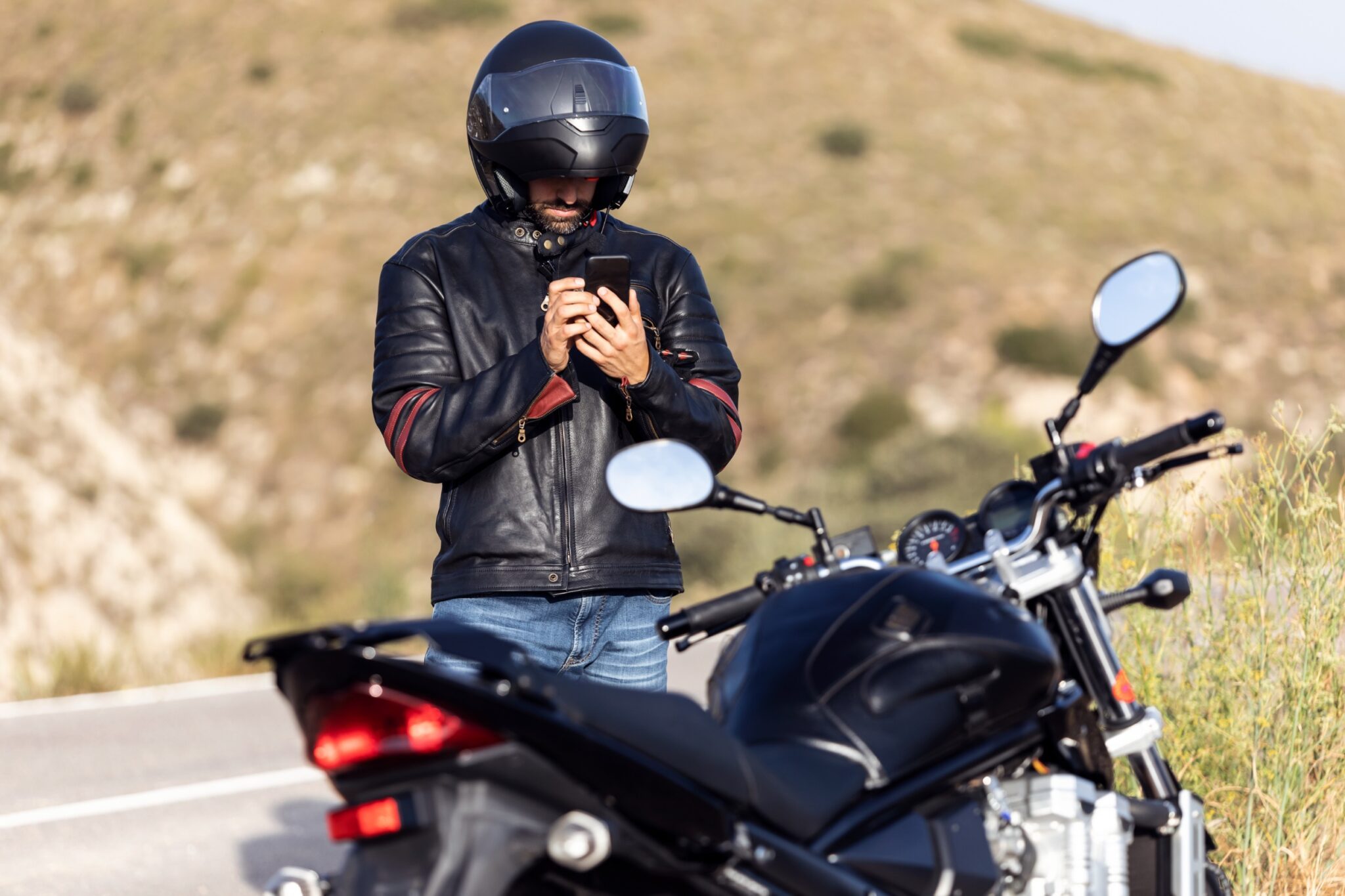 un motard regarde son téléphone