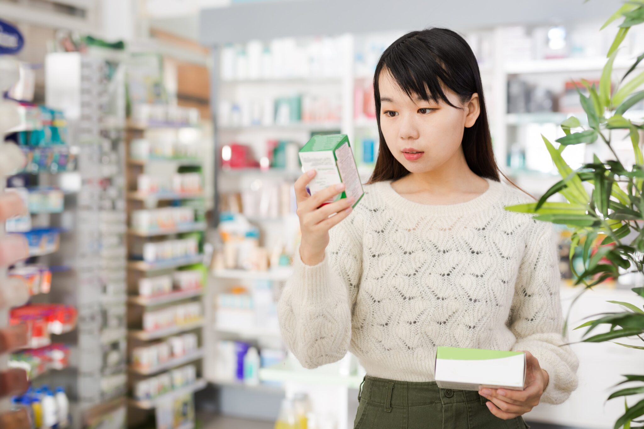 Femme qui regarde la boîte d'un médicament