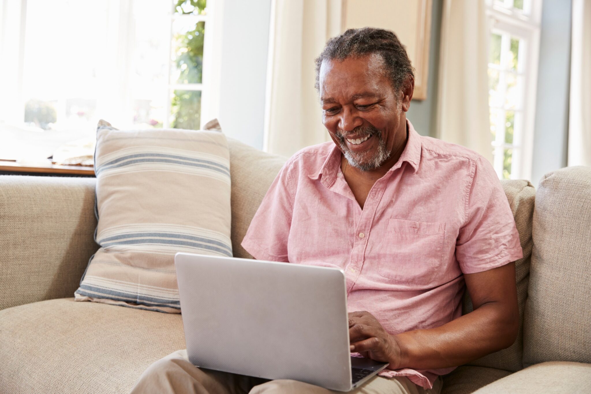 Homme senior qui sourit devant son PC