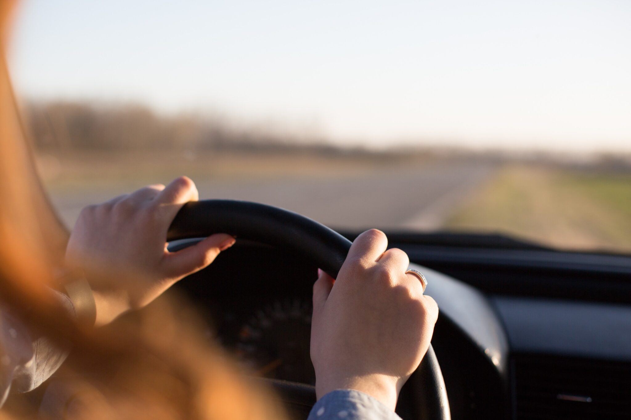 des mains sont posées sur un volant