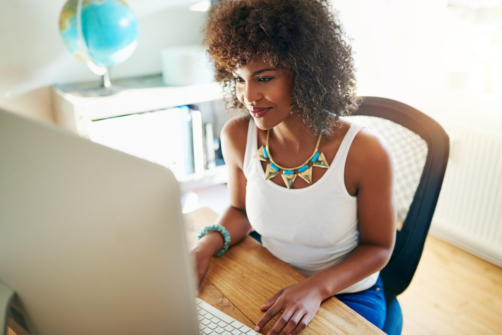 Femme qui sourit devant un PC