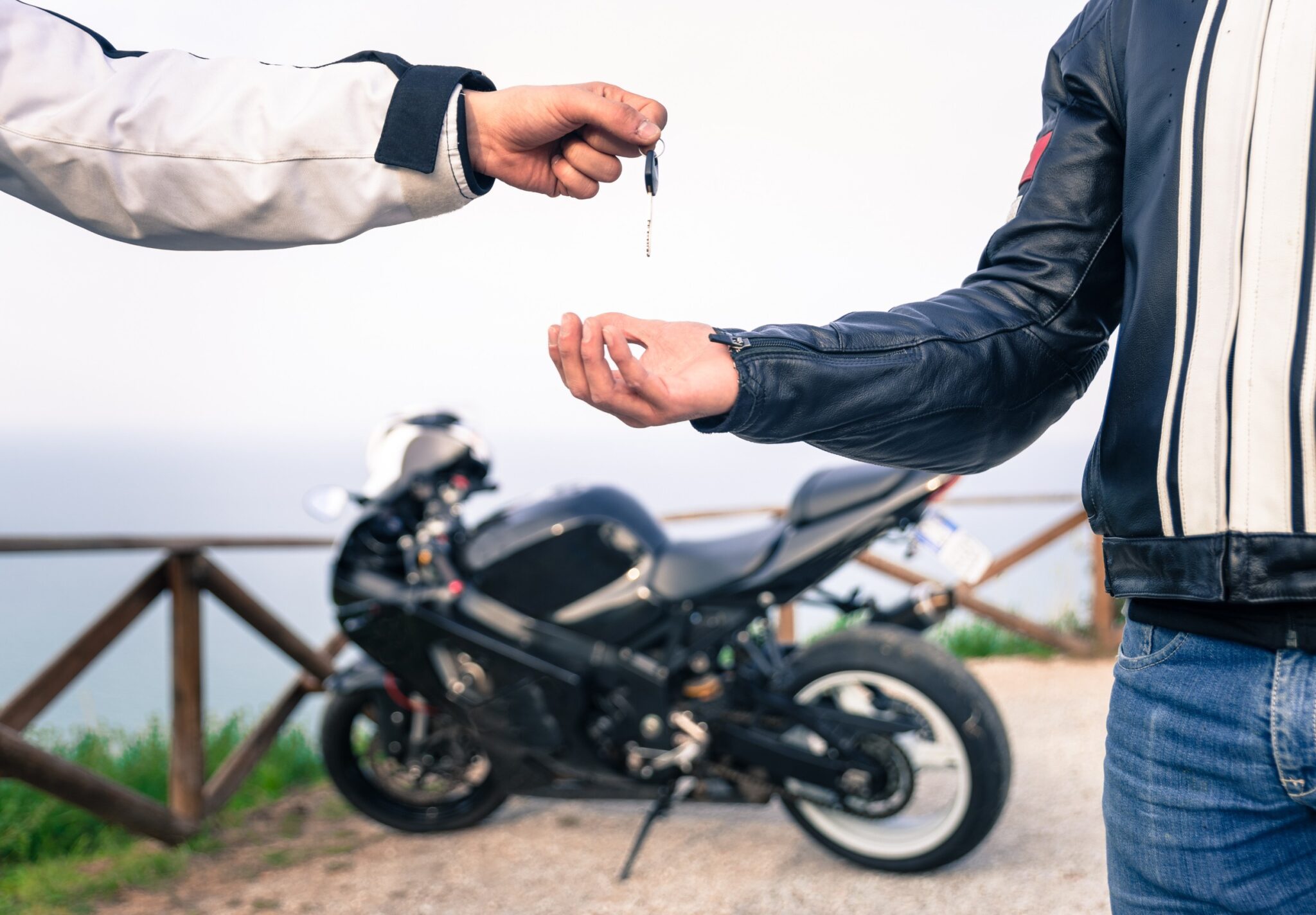 Un homme qui donne les clefs d'une moto à un autre