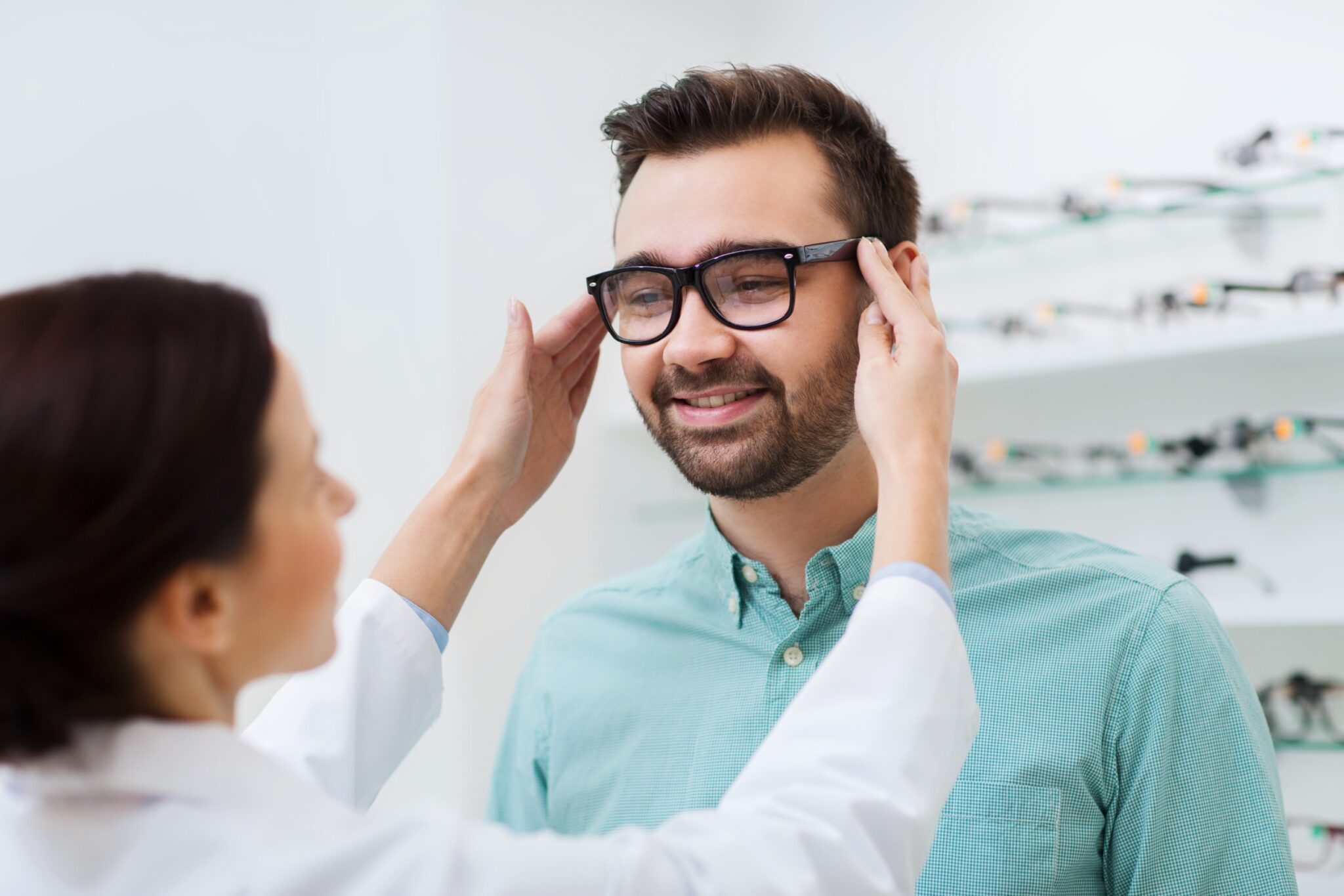 une opticienne ajuste les lunettes d'un client