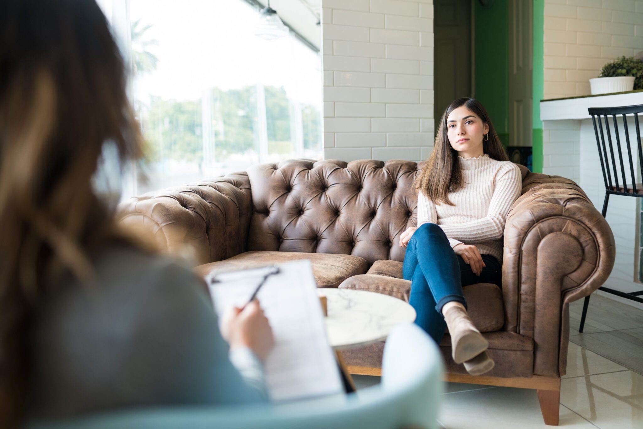 Femme assise sur un canapé et qui parle avec une psychologue
