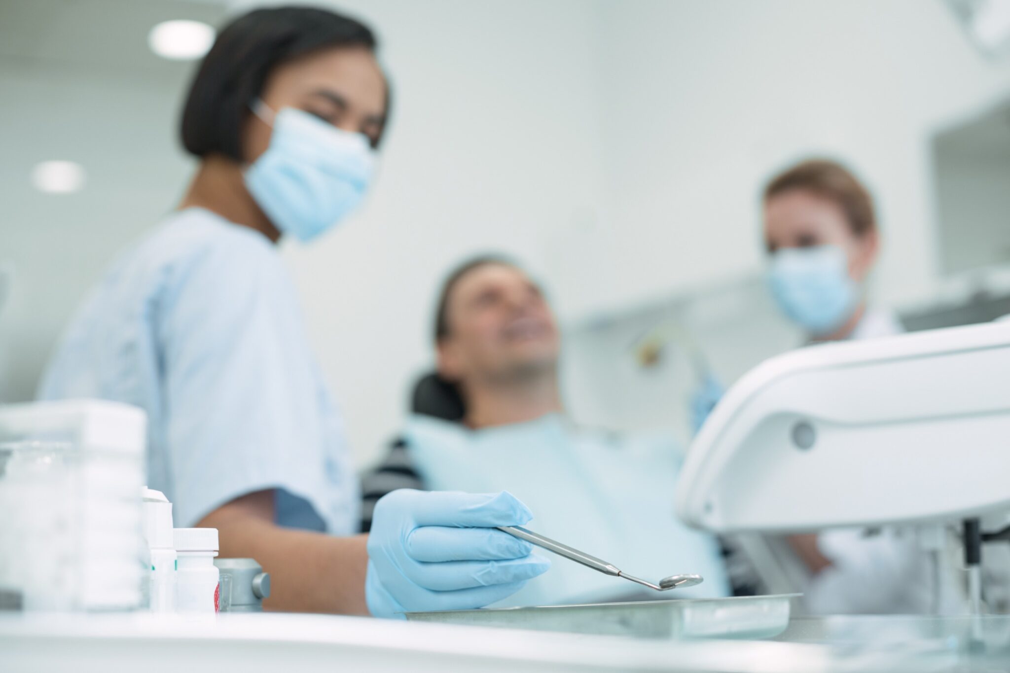 Equipe de dentistes s'occupe d'un patient assis sur une chaise