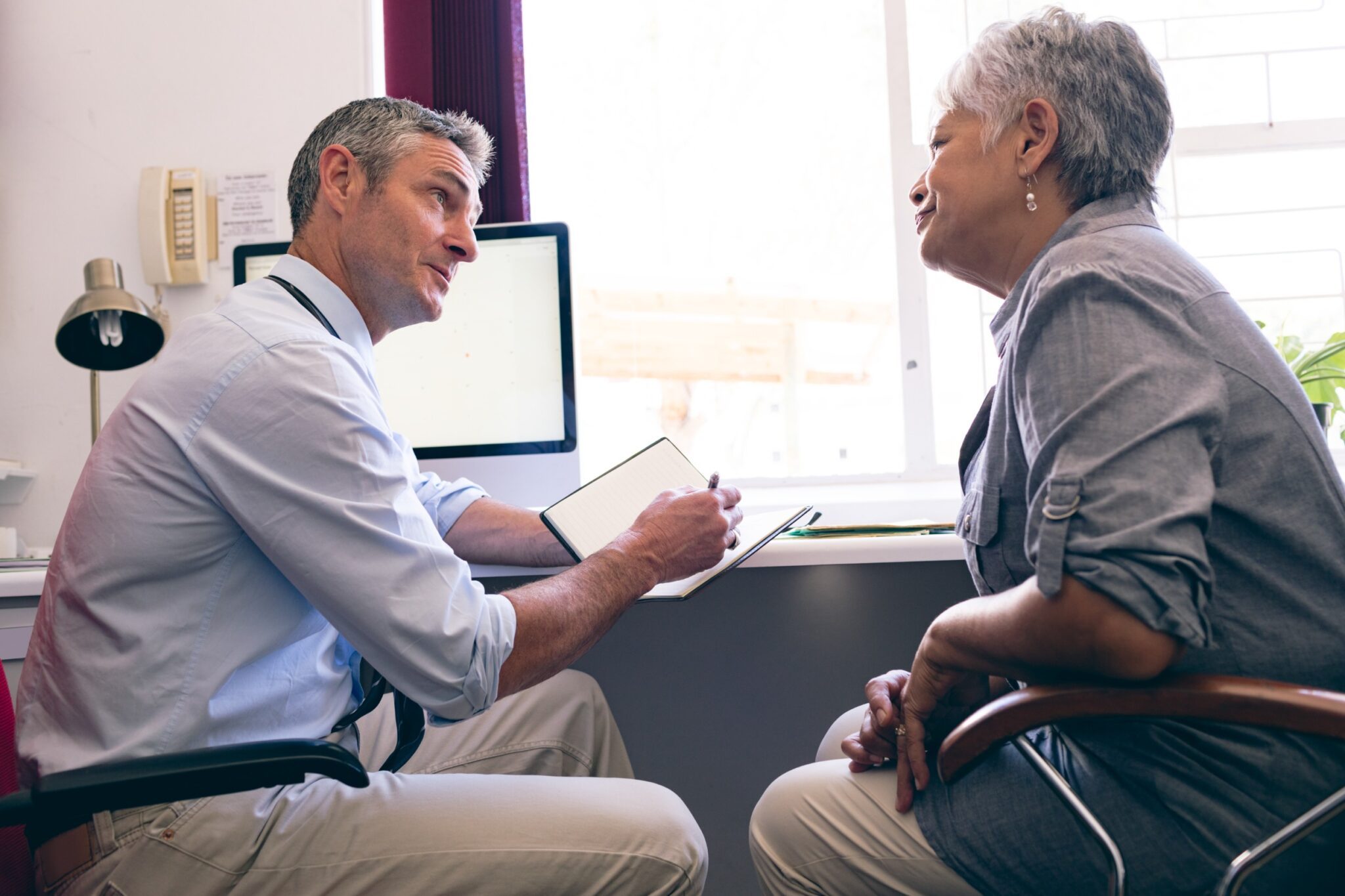 un médecin discute avec une patiente retraitée