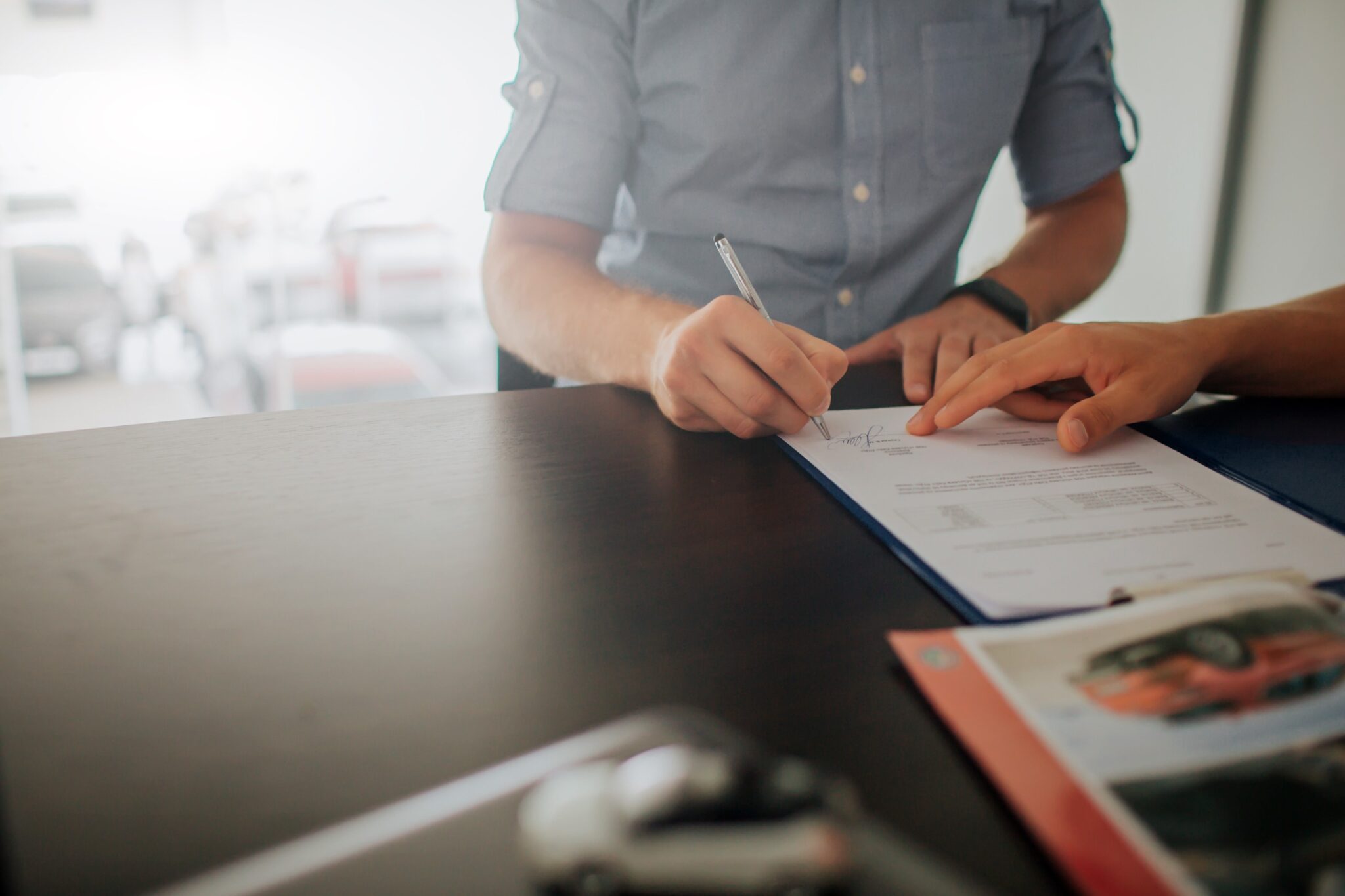 un homme signe un contrat de location de voiture