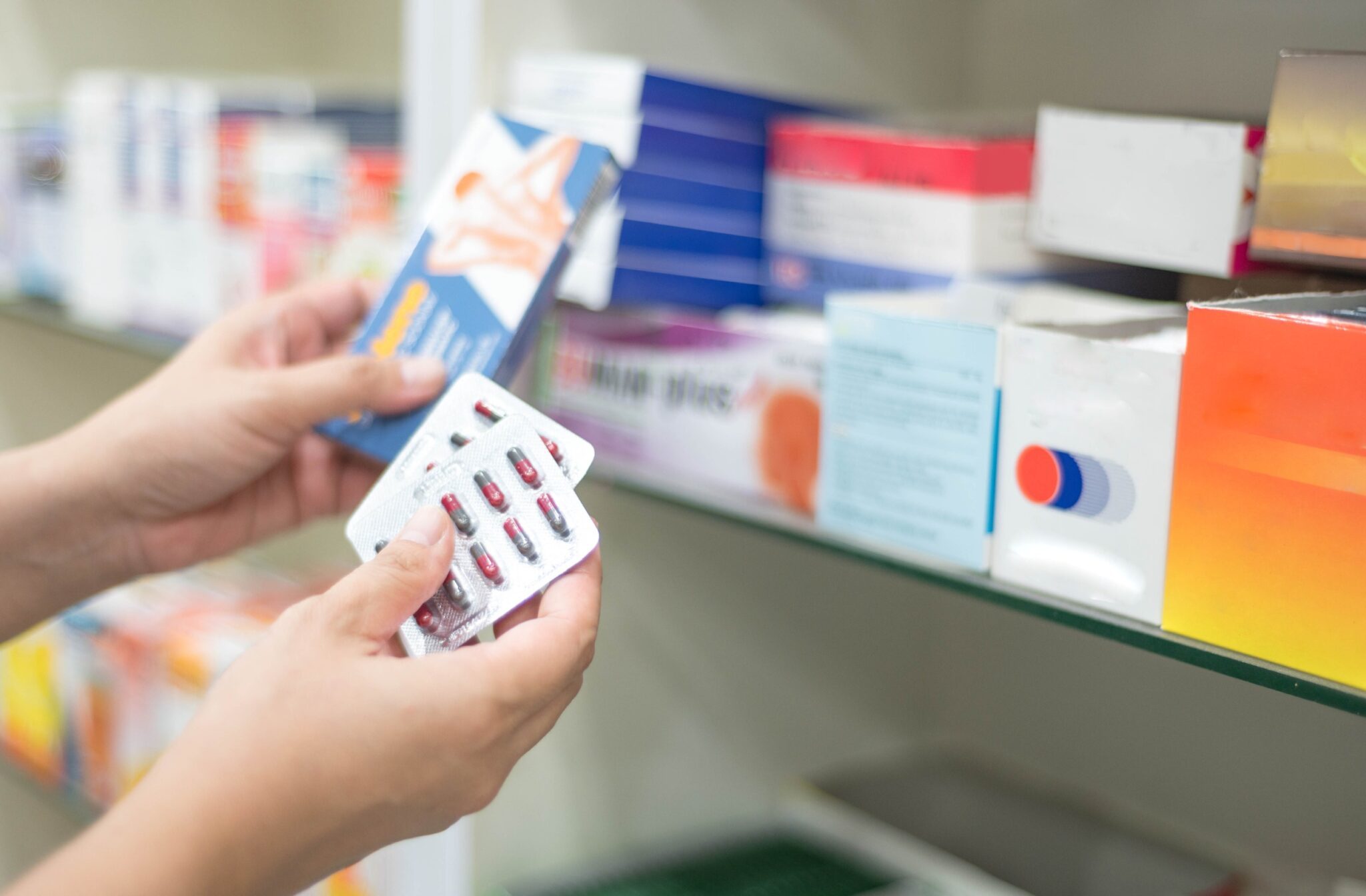 Femme tenant un pack de capsules de médicaments à la pharmacie à vendre au patient