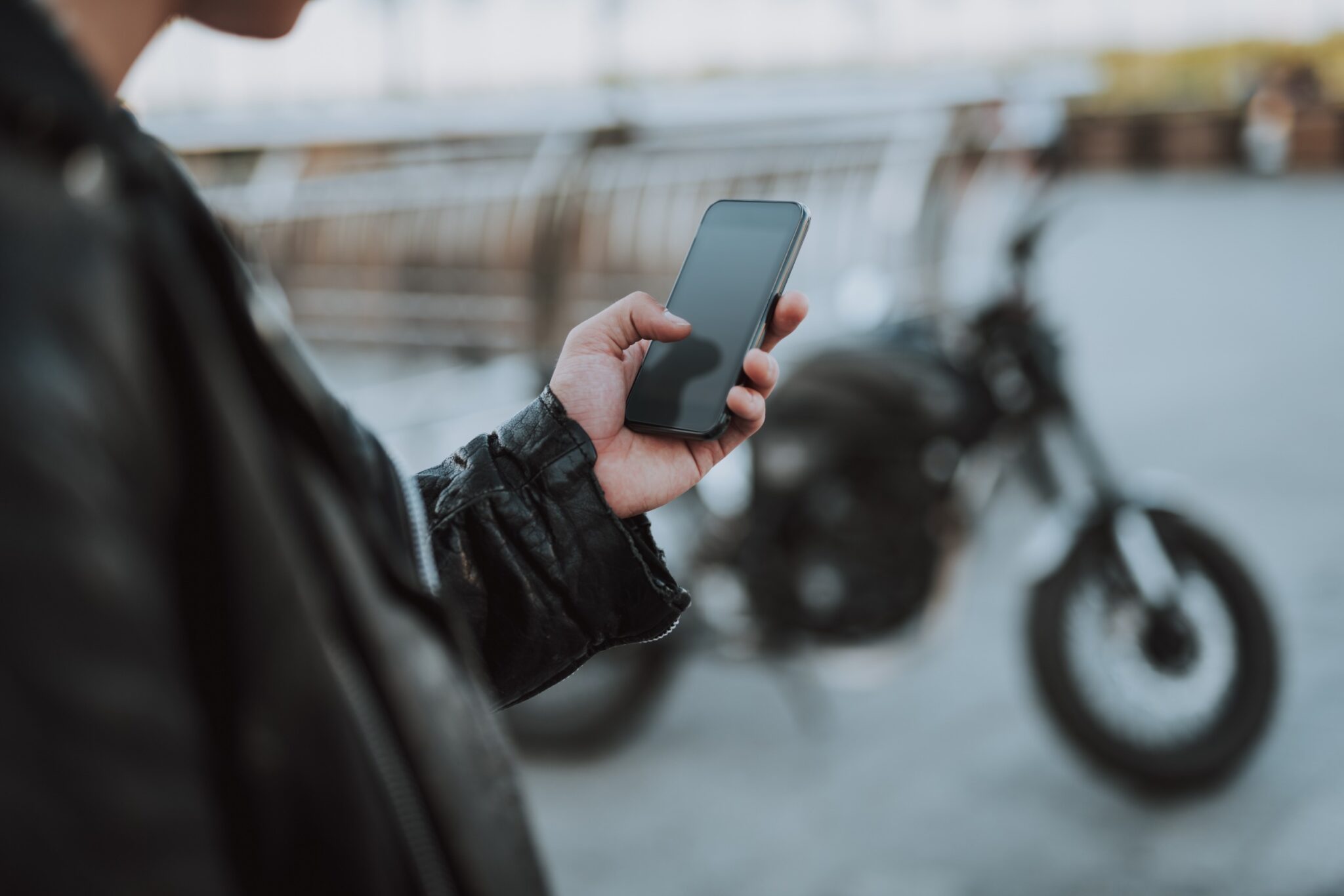 gros plan sur la main d'un motard tenant son téléphone