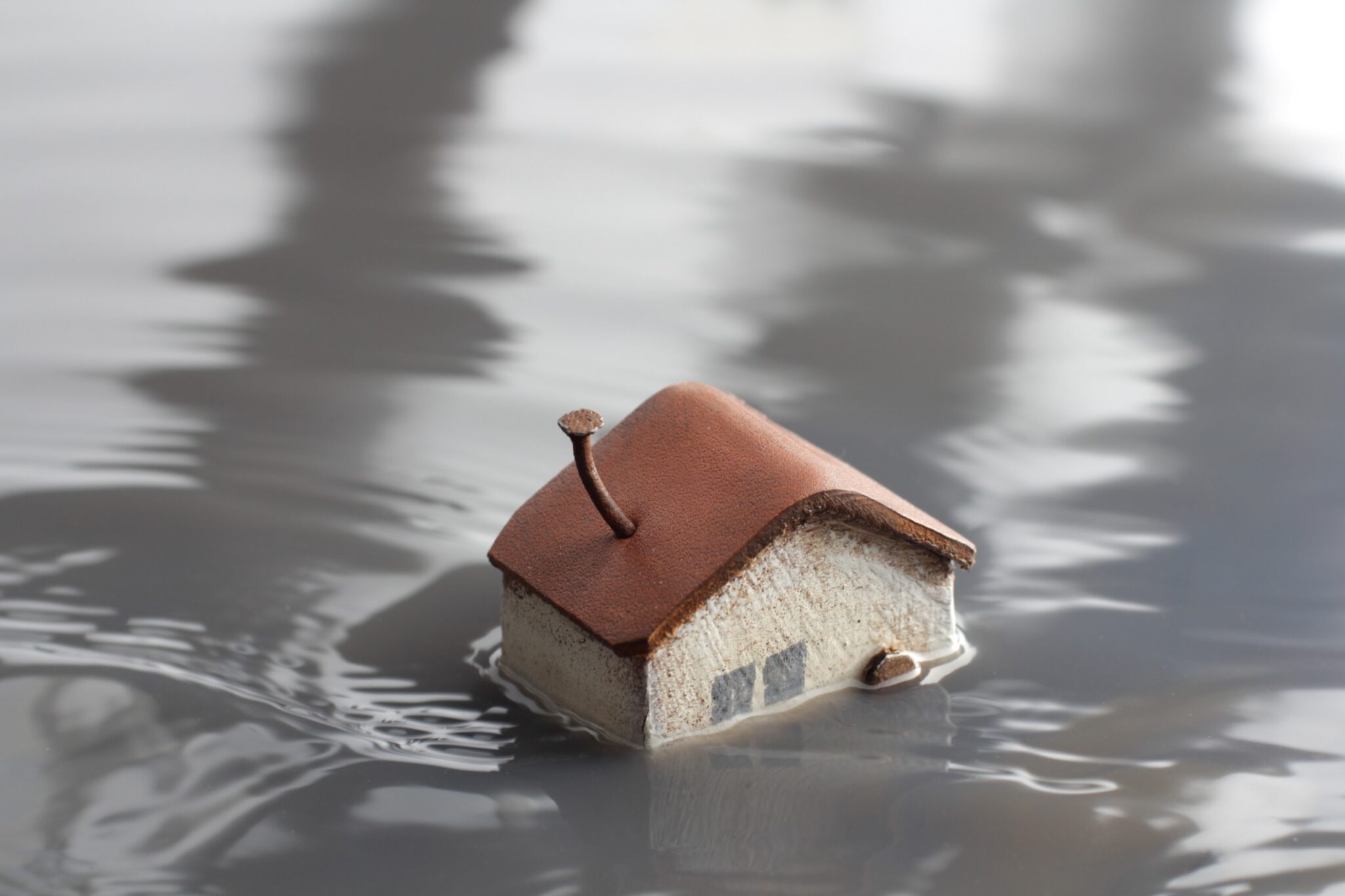 une maison miniature est submergée par de l'eau