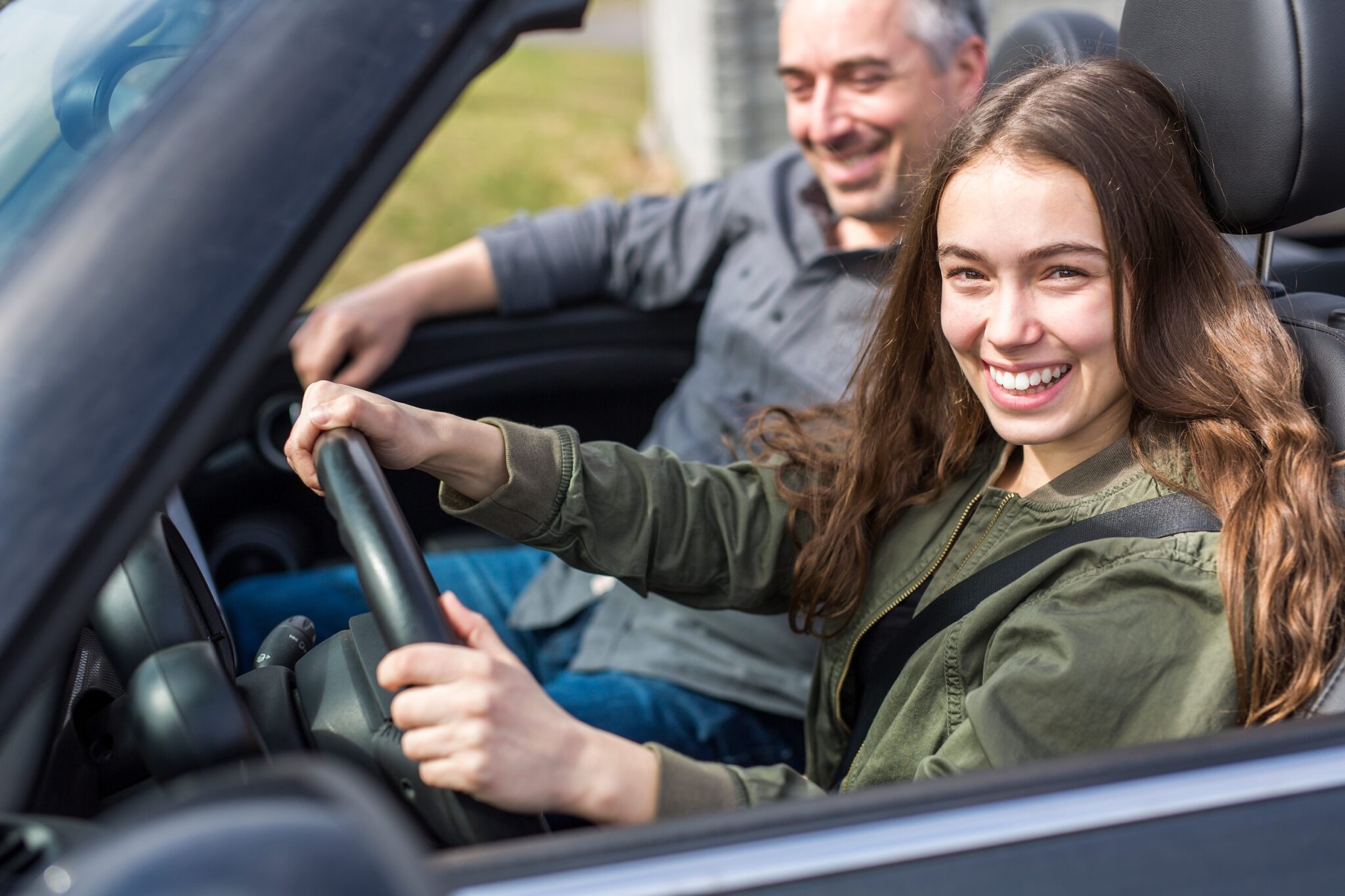 une jeune fille conduit avec son père