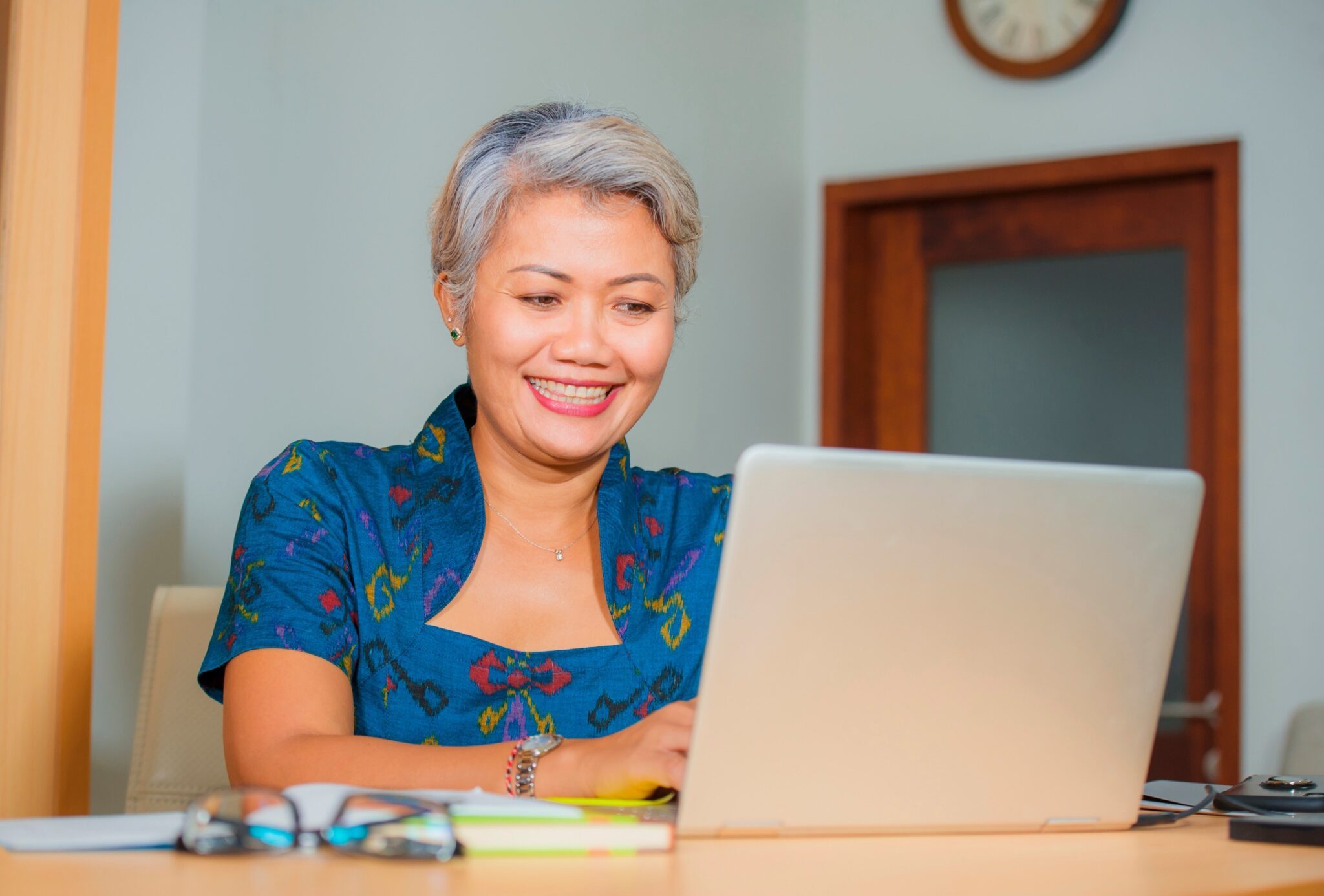 Femme qui sourit devant son PC portable
