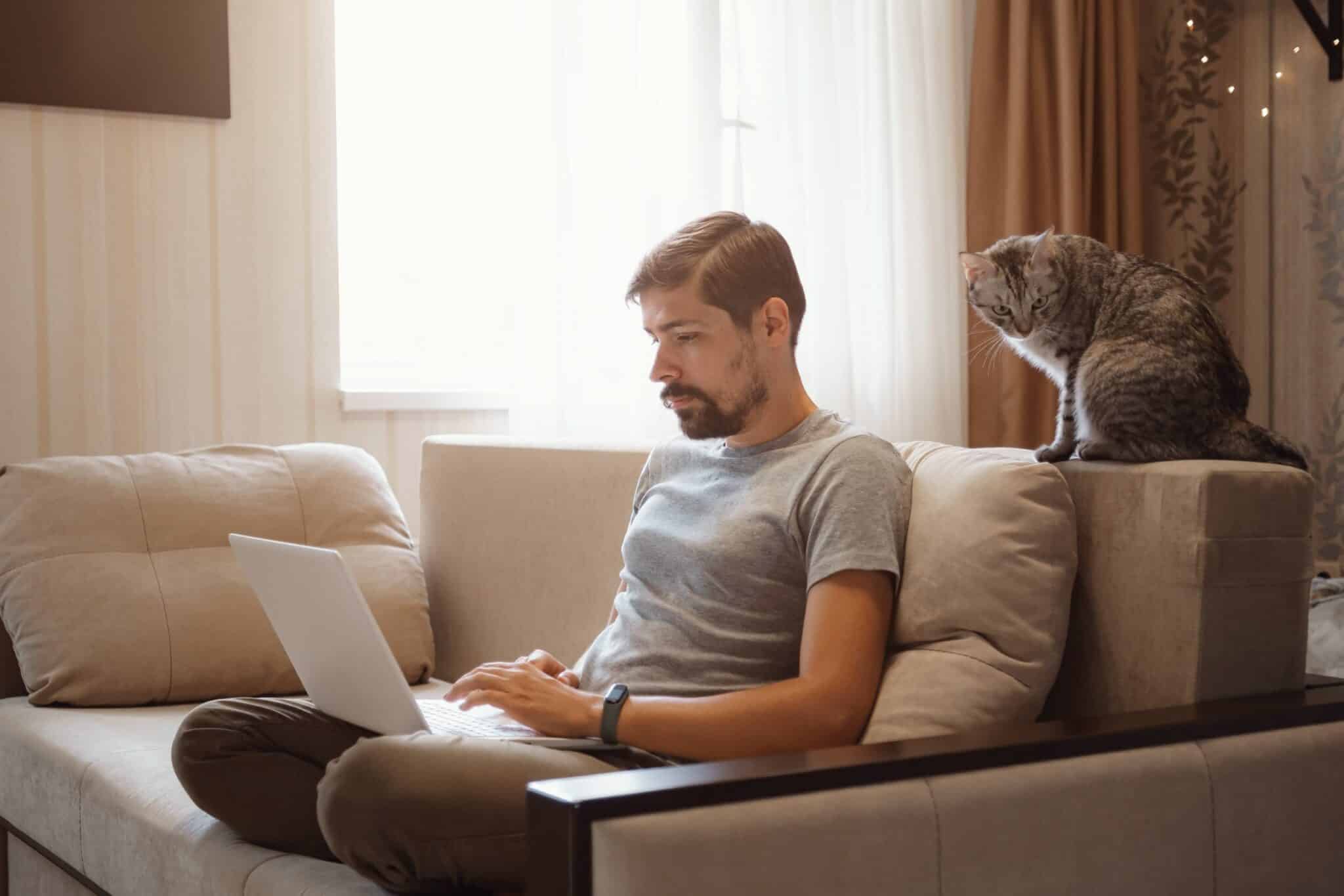 un homme est assis sur son canapé et compare les assurances habitation