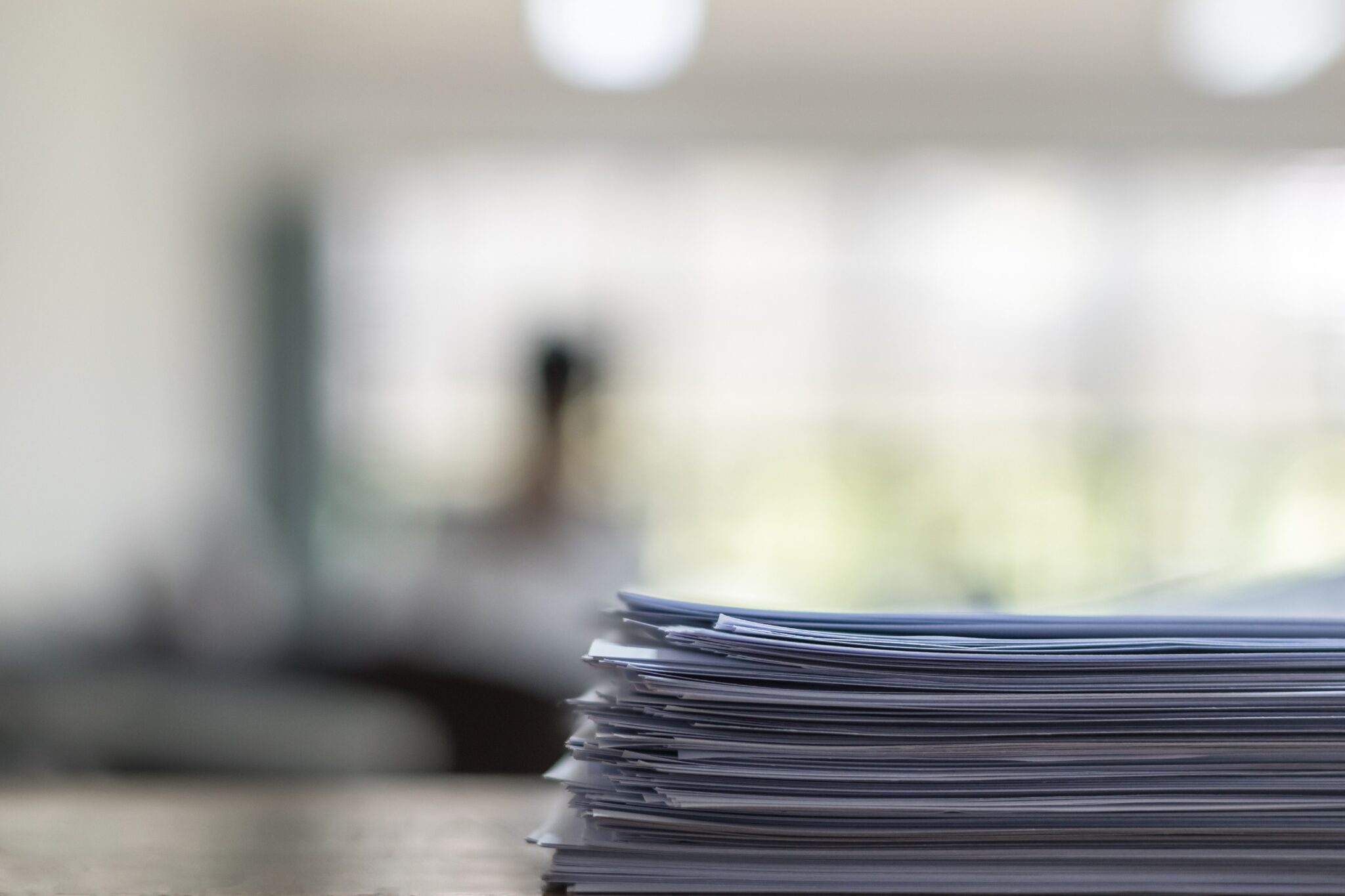 une pile de dossiers de location d'appartement sont posés sur une table