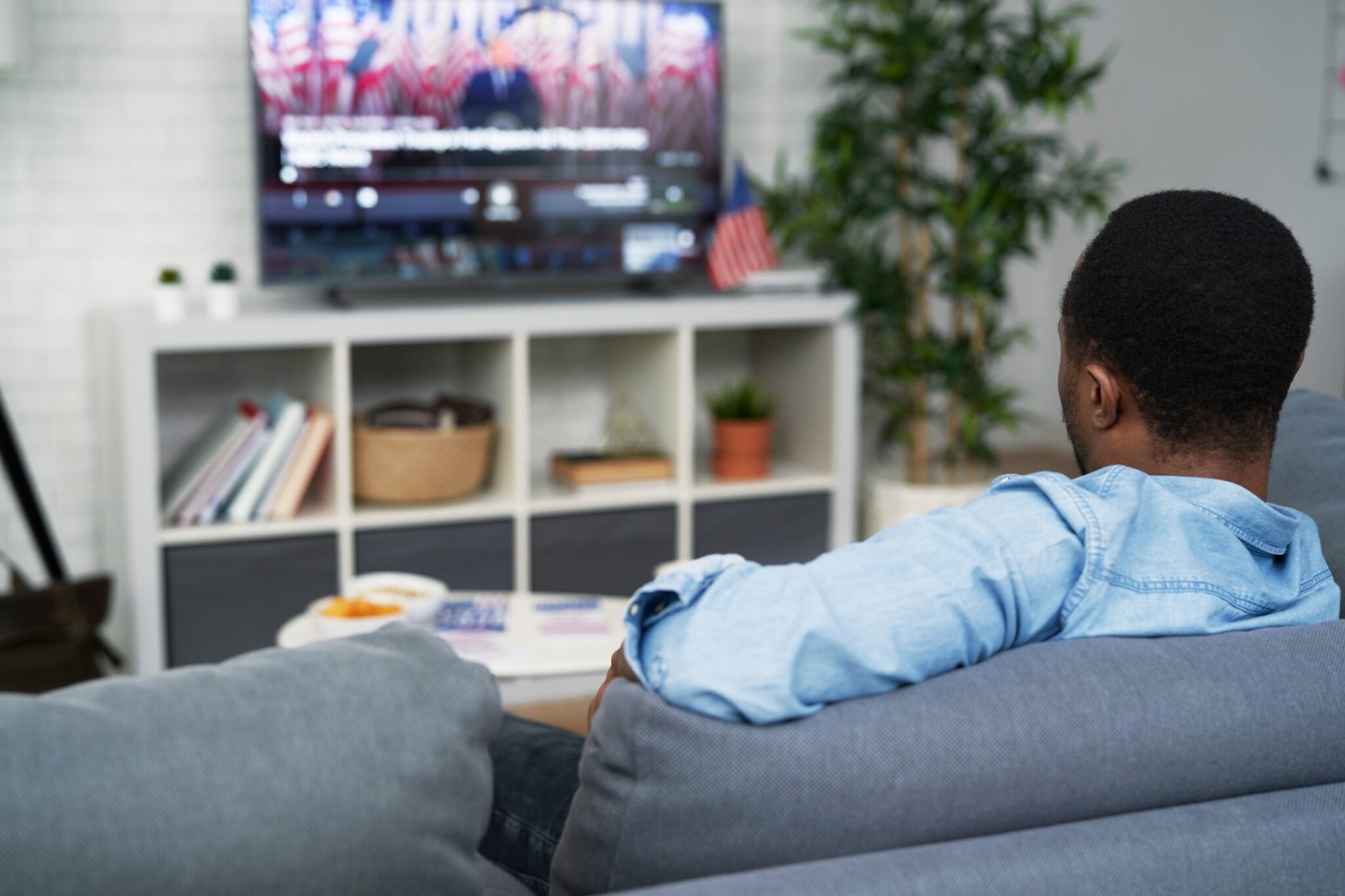 un homme profite de la sa box Free en regardant la télé