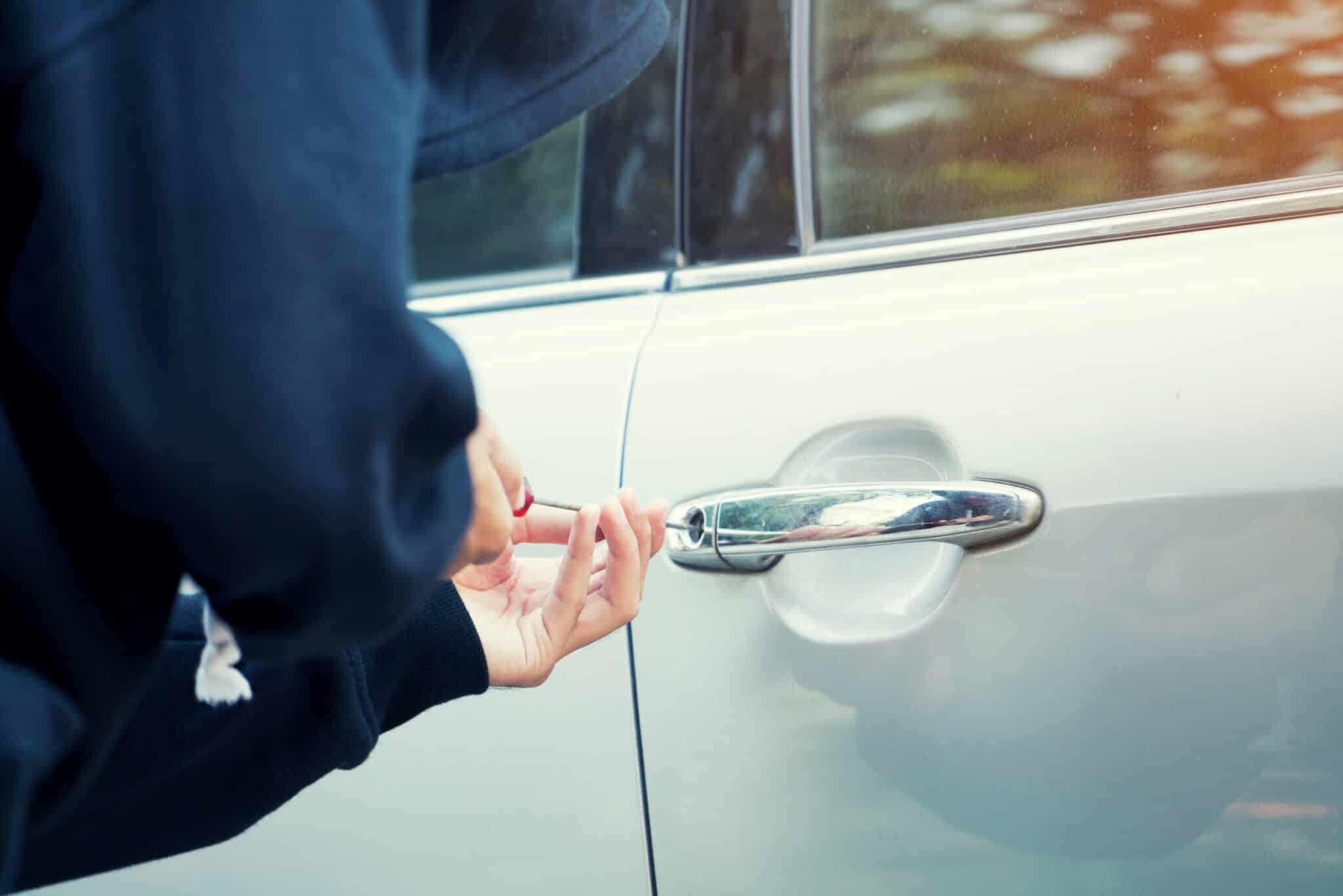 Une personne qui est en train de forcer la serrure d'une voiture