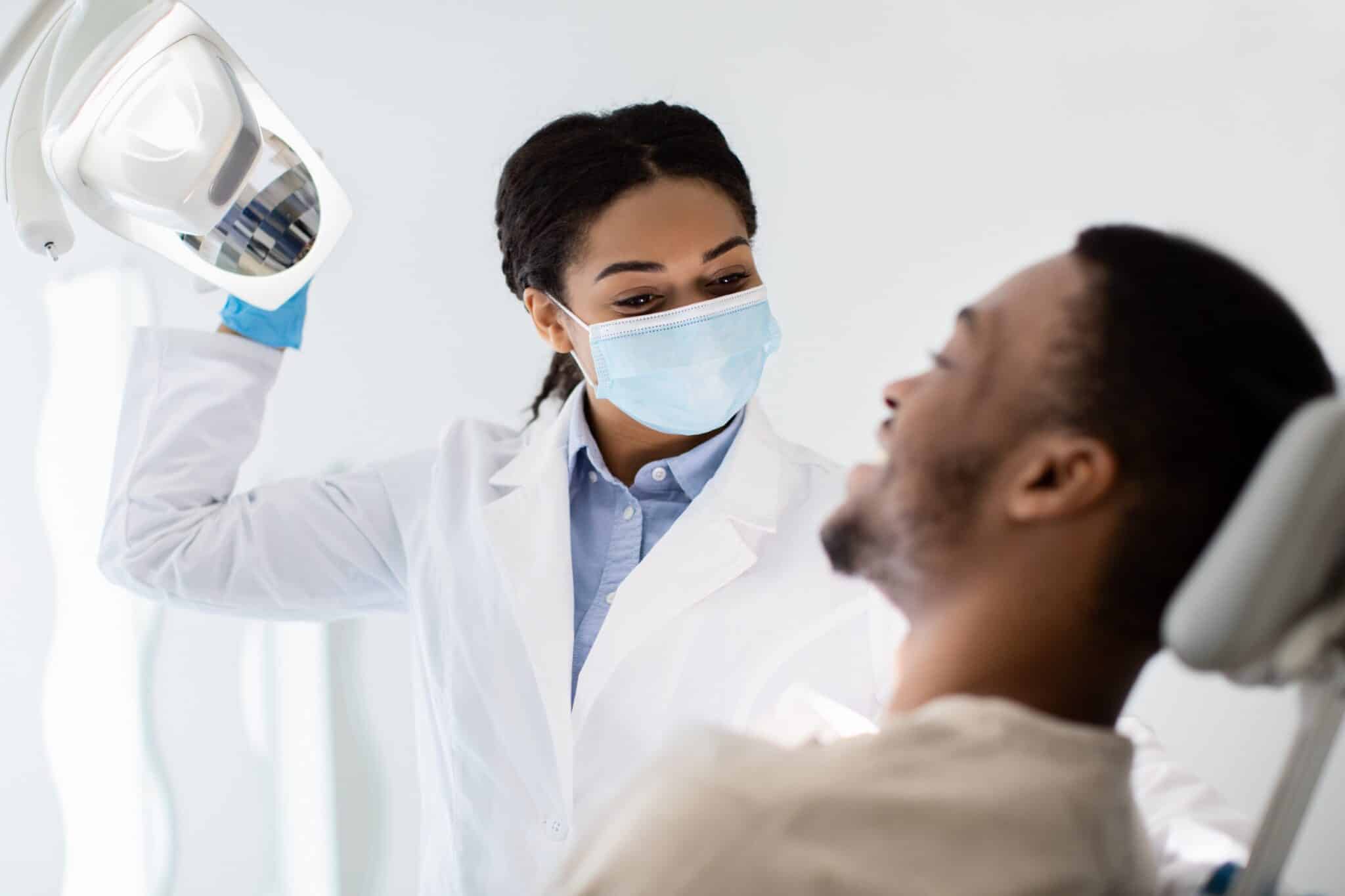 Une dentiste avec un patient installé sur la chaise