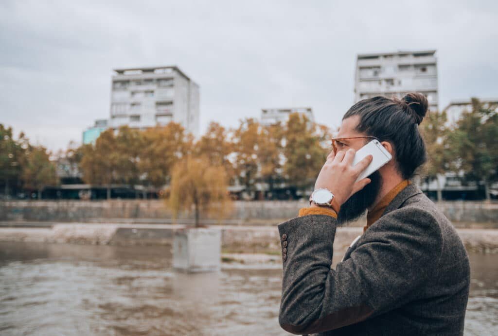 Homme au téléphone proche d'un cours d'eau