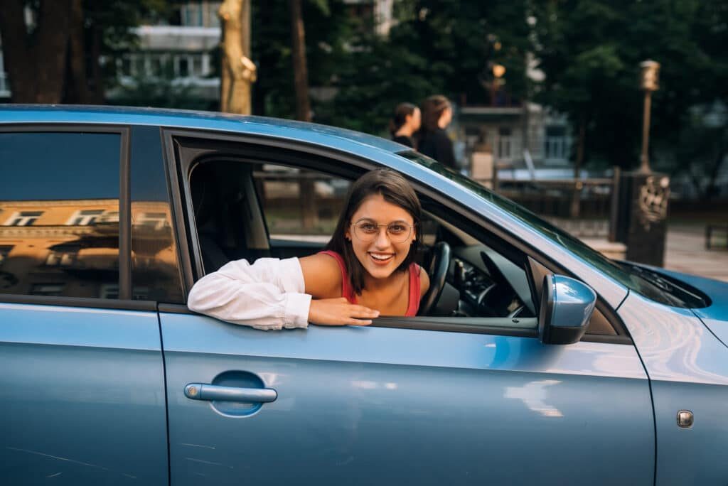 Femme qui sourit au volant d'une voiture